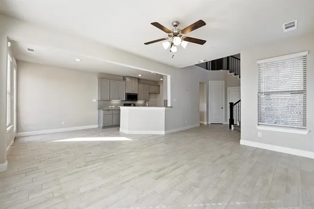 a view of a livingroom with a ceiling fan a kitchen space with a sink