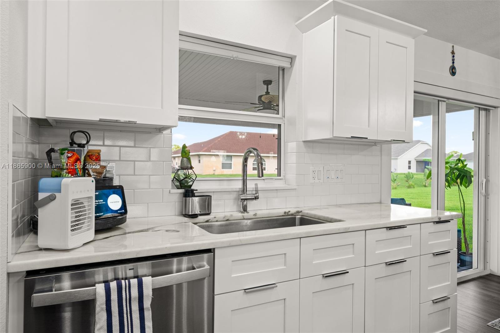 5810 Columbus Boulevard Sebring, FL 33872 - Photo 11 of 49 a kitchen with stainless steel appliances white cabinets a stove and a window