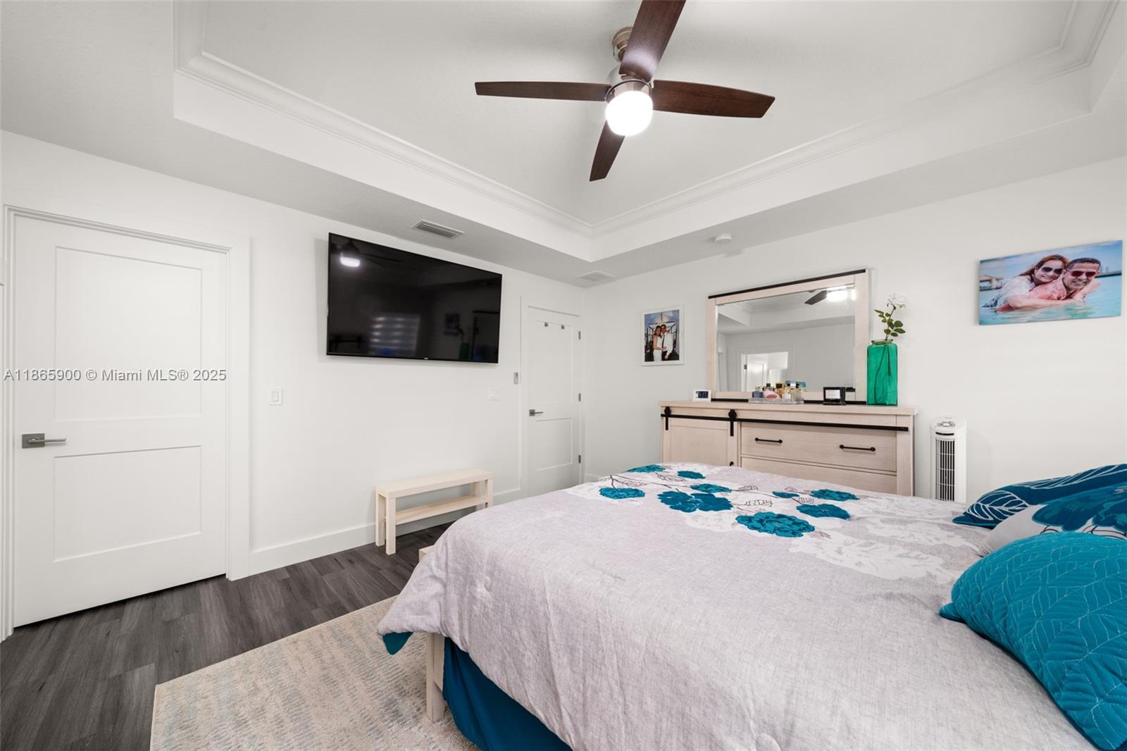 5810 Columbus Boulevard Sebring, FL 33872 - Photo 16 of 49 a bedroom with a bed a flat screen tv and a chandelier