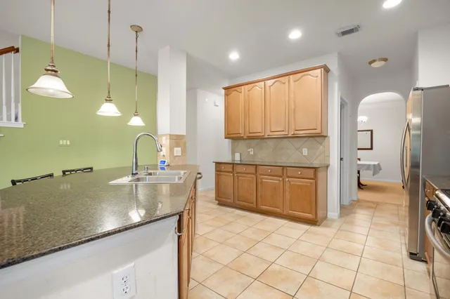 a kitchen with stainless steel appliances granite countertop a kitchen island a table and chairs in it