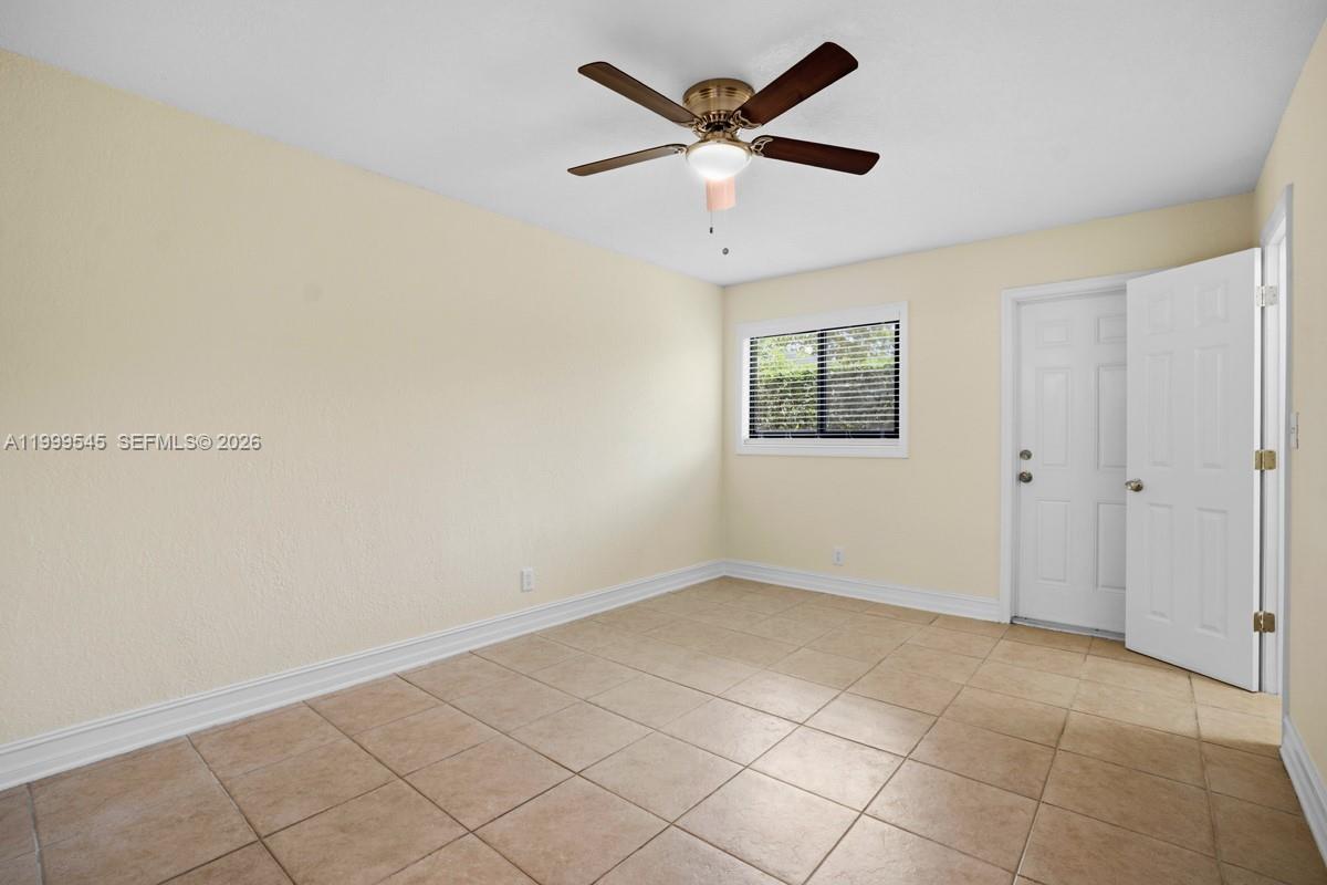 7604 Southwest 10th Court, Unit 2 Pompano Beach, FL 33068 - Photo 13 of 19 an empty room with a ceiling fan and window