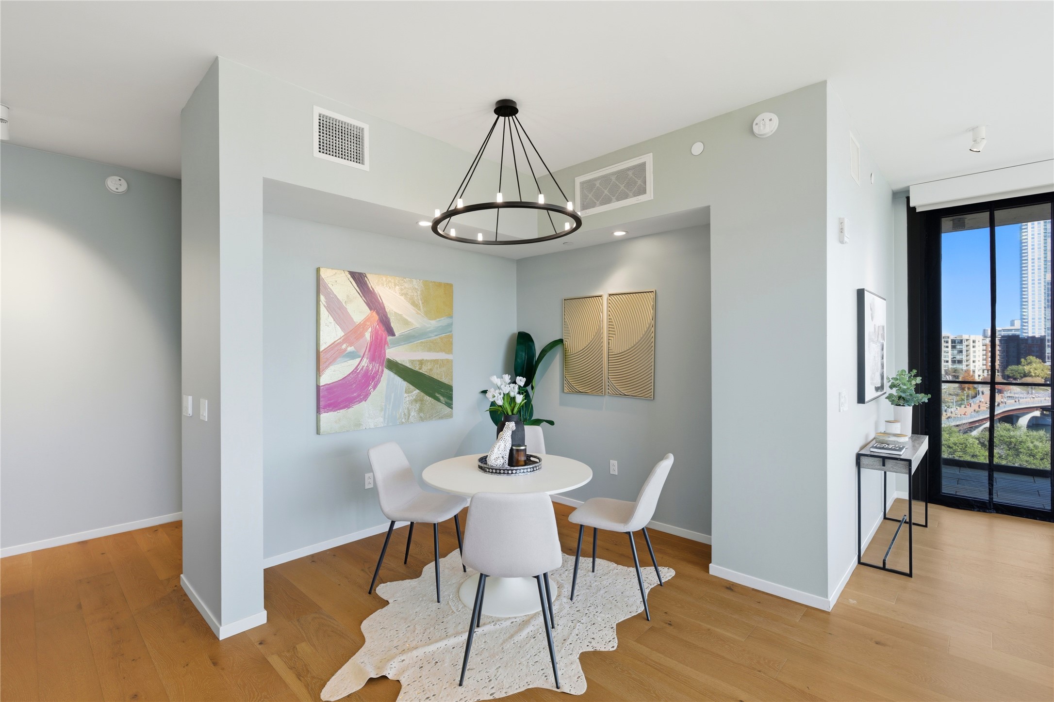 1211 West Riverside Drive, Unit 6B Austin, TX 78704 - Photo 11 of 40 a dining room with wooden floor a chandelier a glass table and chairs