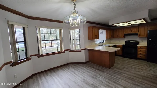 a large kitchen with granite countertop a large counter top space appliances and cabinets