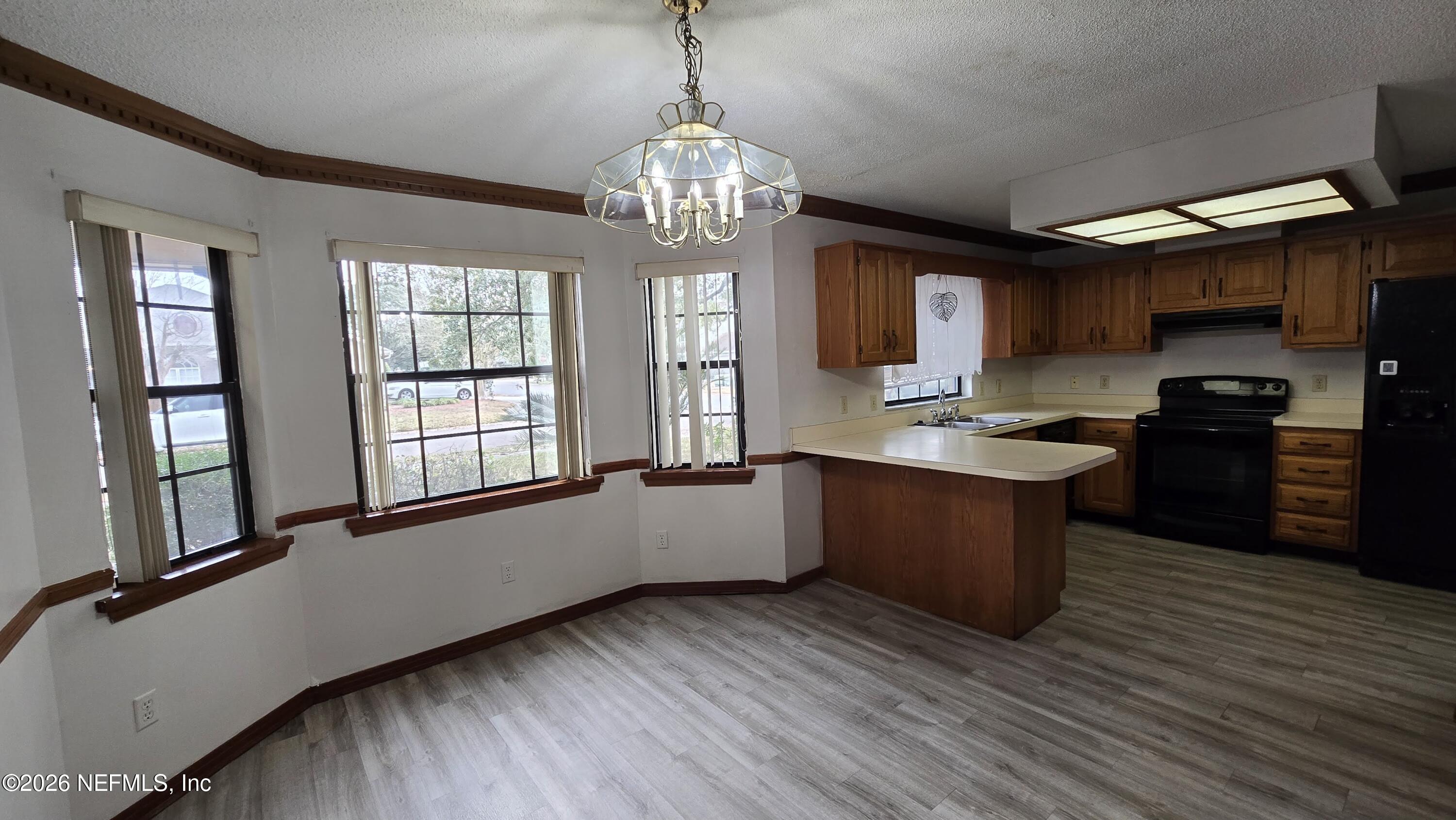 8532 Bandera Circle East Jacksonville, FL 32244 - Photo 9 of 47 a large kitchen with stainless steel appliances granite countertop a stove a refrigerator a sink dishwasher and wooden cabinets with wooden floor