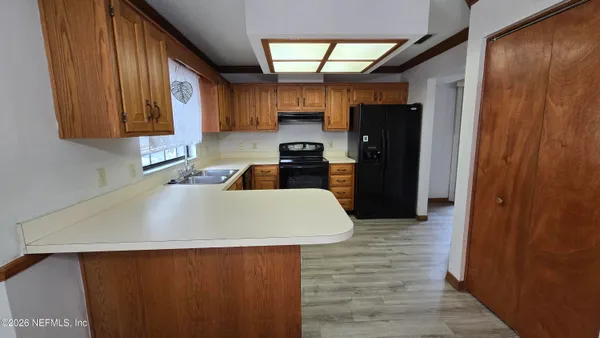 a kitchen with a sink a stove and cabinets