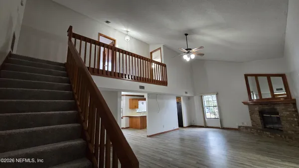 a view of a livingroom with wooden floor and a fireplace