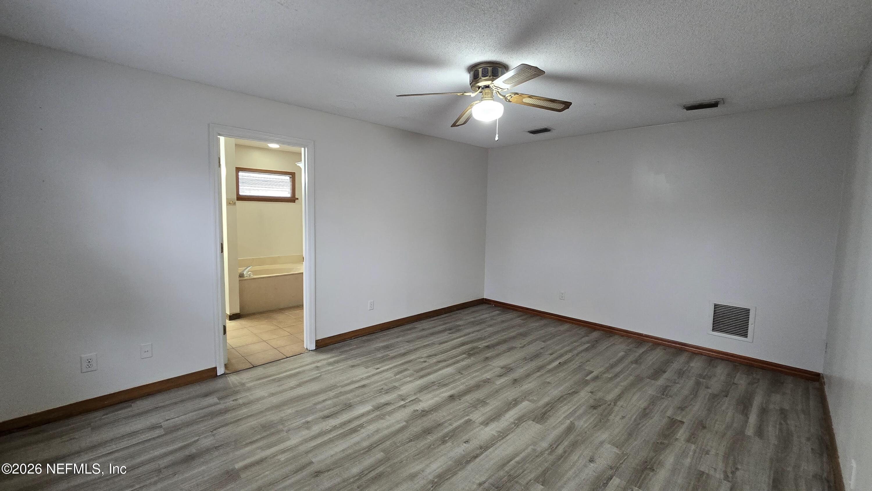 8532 Bandera Circle East Jacksonville, FL 32244 - Photo 23 of 47 a view of an empty room with wooden floor and a window