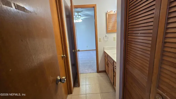 an empty room with a window and a ceiling fan