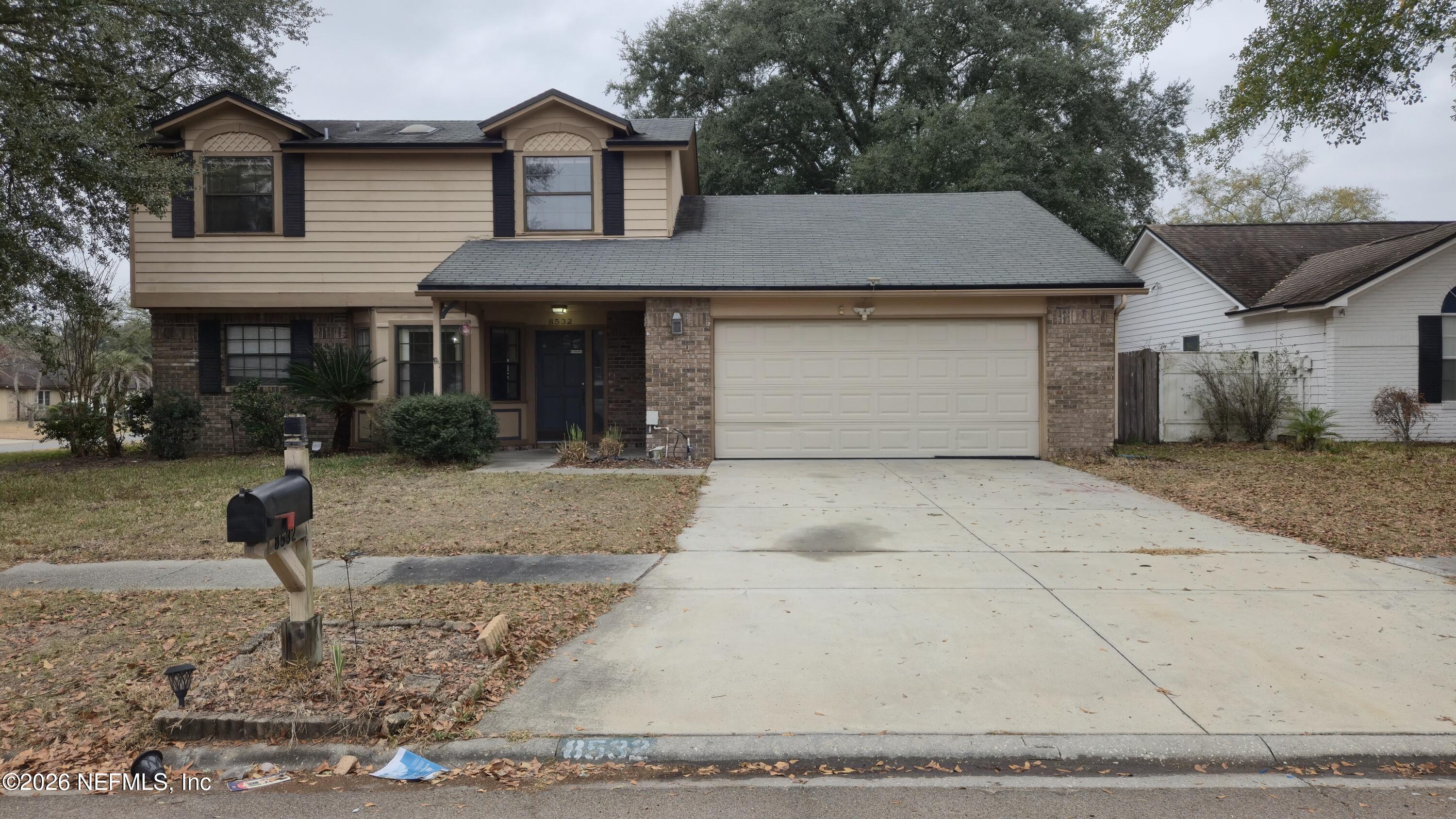 8532 Bandera Circle East Jacksonville, FL 32244 - Photo 2 of 47 a front view of a house with a yard and garage