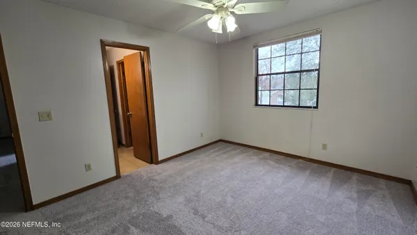 an empty room with closet and windows