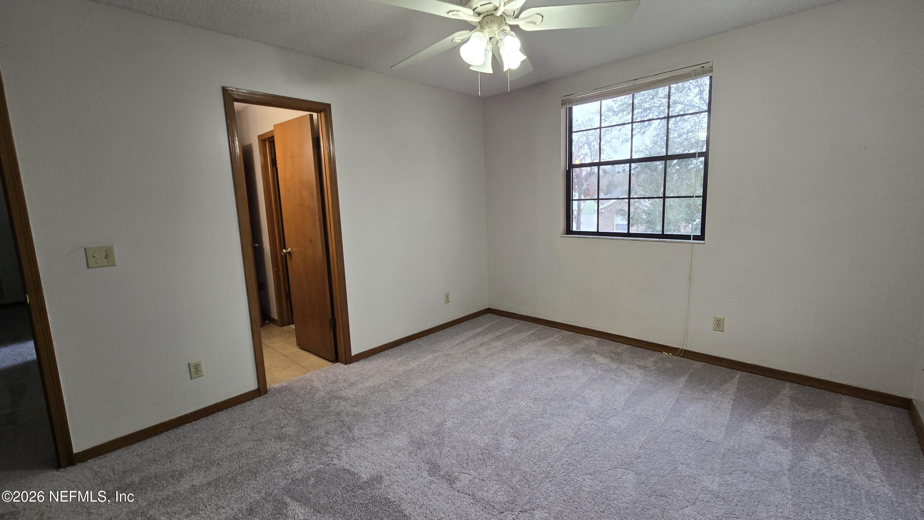 8532 Bandera Circle East Jacksonville, FL 32244 - Photo 40 of 47 an empty room with windows and chandelier fan