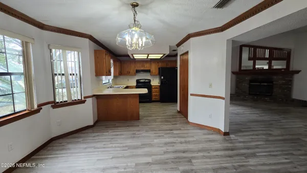 a view of a hallway with wooden floor and a dining room
