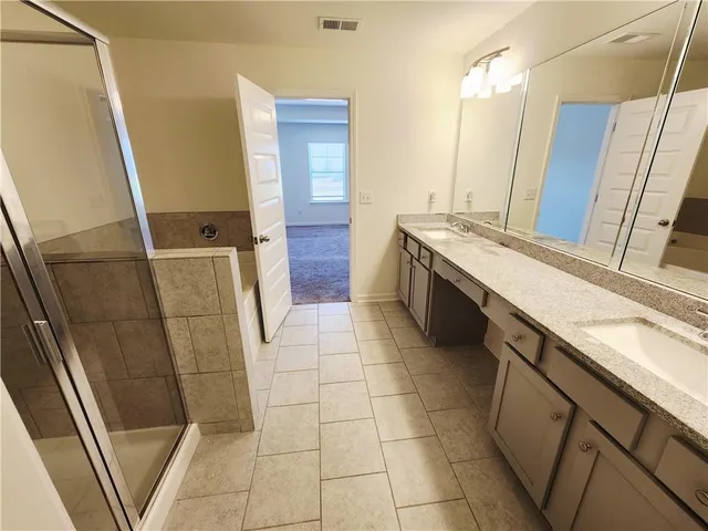 a bathroom with a sink and mirror with bathtub