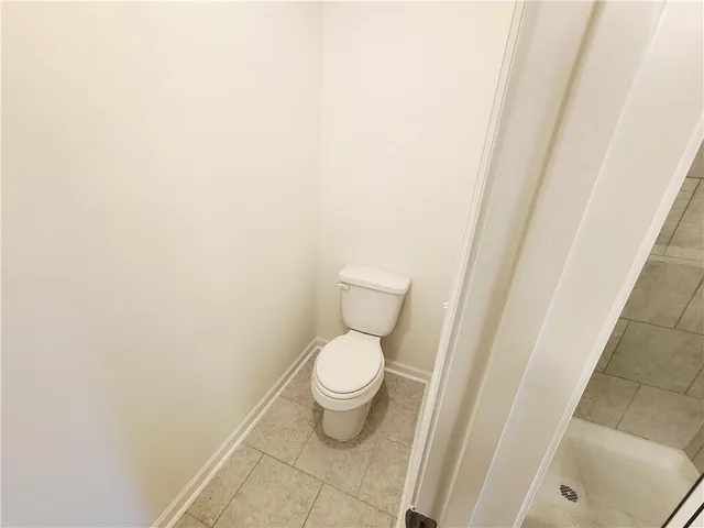 a white toilet sitting next to a shower