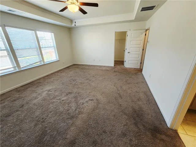 an empty room with windows and fan
