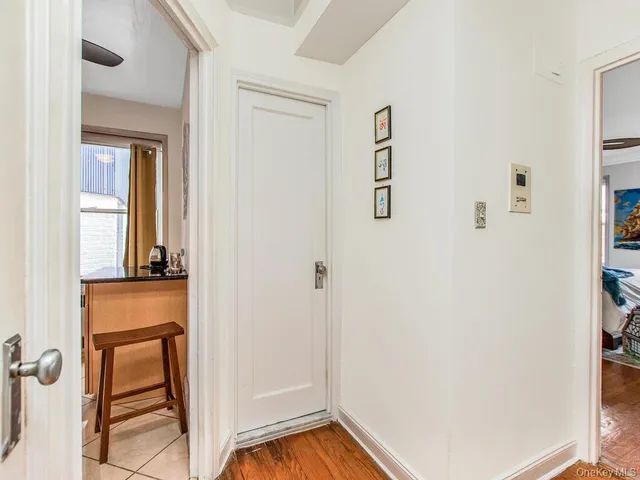 a view of a hallway with wooden floor and a bathroom