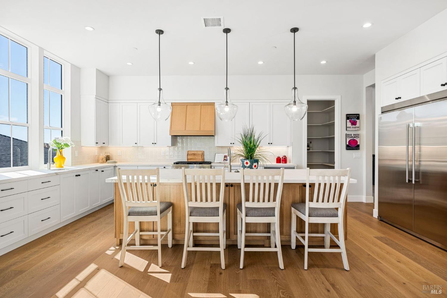3712 Crown Hill Drive Santa Rosa, CA 95404 - Photo 19 of 71 This kitchen has a large country style sink in the island and another smaller sink under these large windows looking out to the southwest views. Notice the Walkin pantry at the rear of this photo and the oversized built-in refrigerator/freezer.