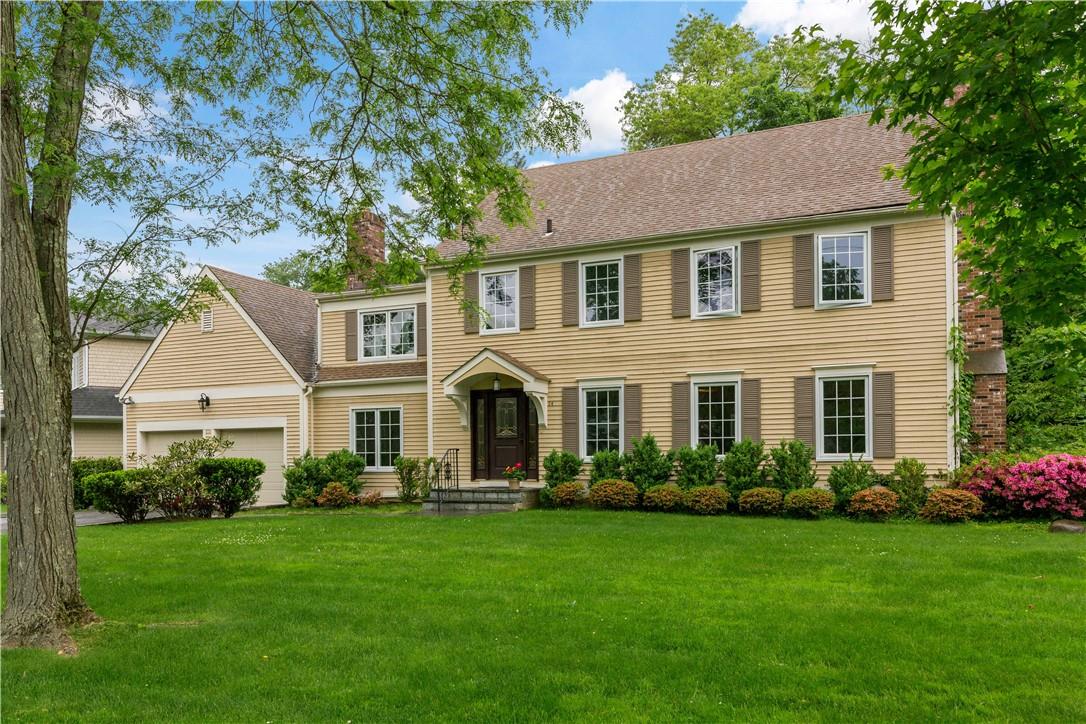 a front view of a house with a yard and trees