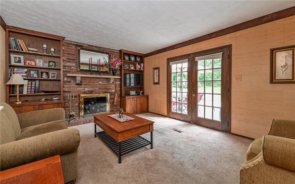 1392 Old Meadow Road Pittsburgh, PA 15241 - Photo 20 of 34 a living room with furniture a bookshelf and a fireplace