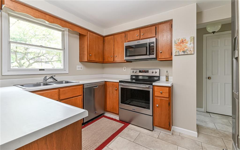 1392 Old Meadow Road Pittsburgh, PA 15241 - Photo 8 of 34 a kitchen with stainless steel appliances granite countertop a stove top oven a sink and a microwave