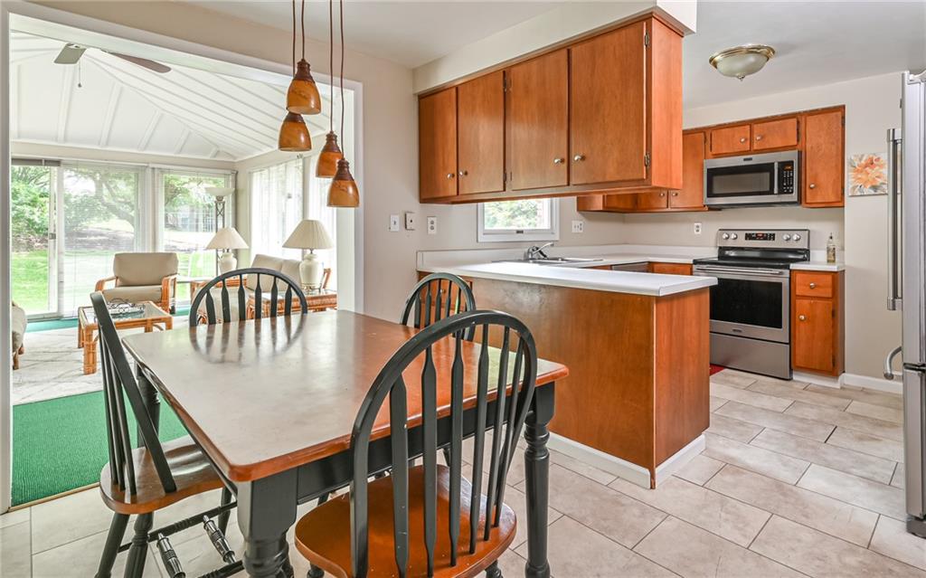 1392 Old Meadow Road Pittsburgh, PA 15241 - Photo 10 of 34 a kitchen with stainless steel appliances granite countertop a stove a sink a microwave dining table and chairs