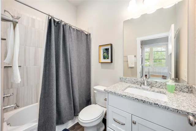 a bathroom with a granite countertop sink toilet and shower