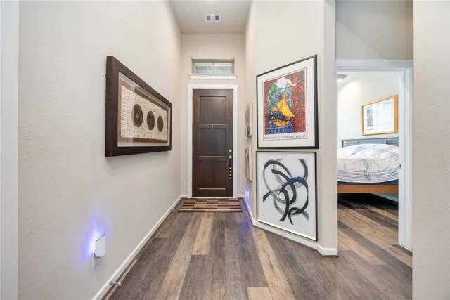 a view of a hallway with wooden floor and furniture