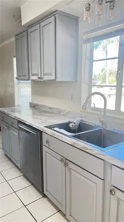 a kitchen with stainless steel appliances granite countertop white cabinets and window