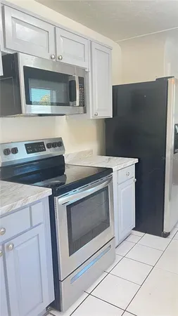 a kitchen with granite countertop white cabinets and stainless steel appliances