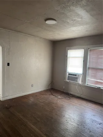 a view of an empty room with window and bathroom
