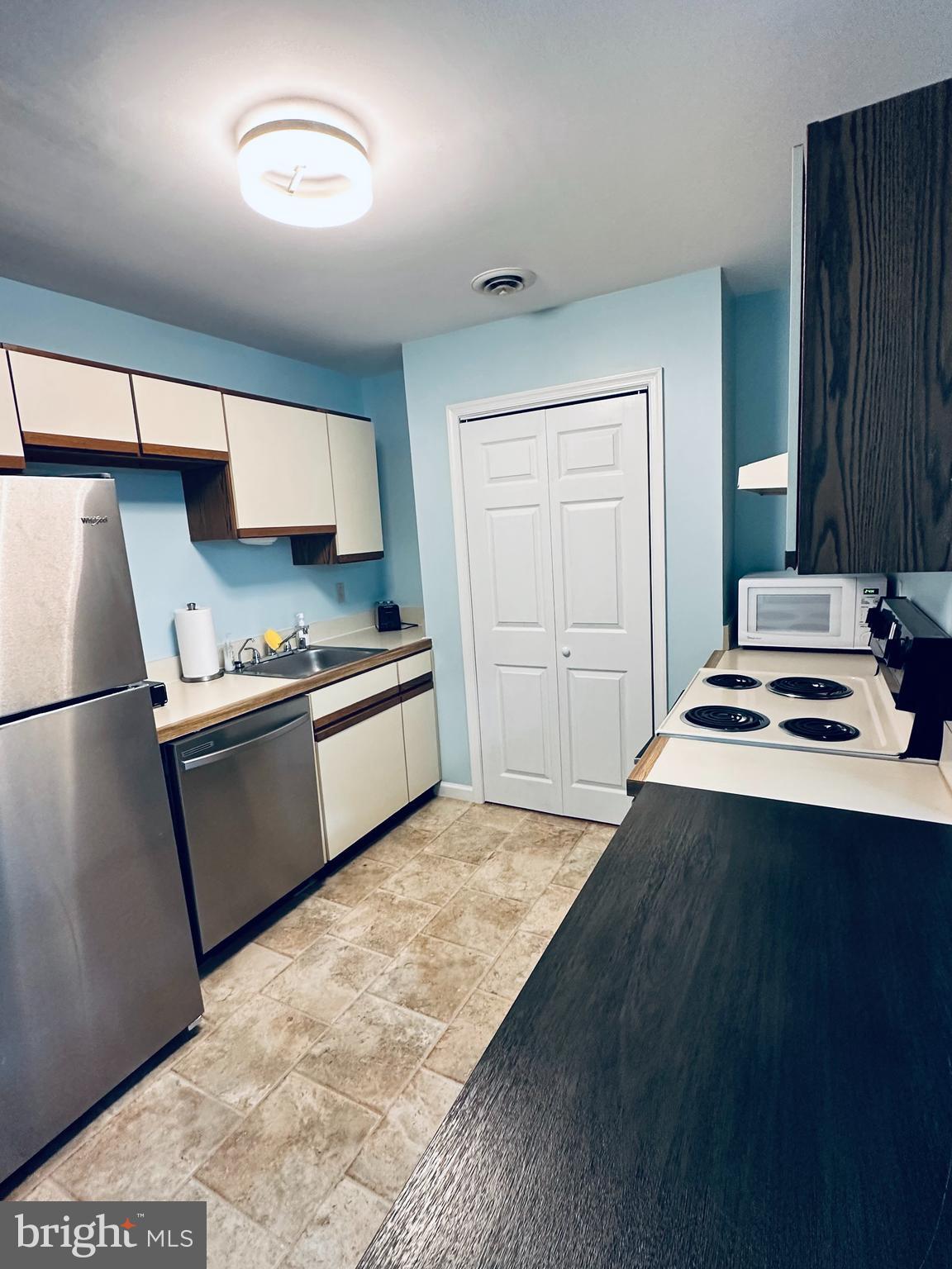 105 120th Street, Unit 84 Ocean City, MD 21842 - Photo 11 of 15 a kitchen with a stove a refrigerator and a sink