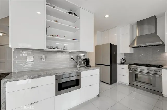 a kitchen with stainless steel appliances kitchen island granite countertop a refrigerator and a sink