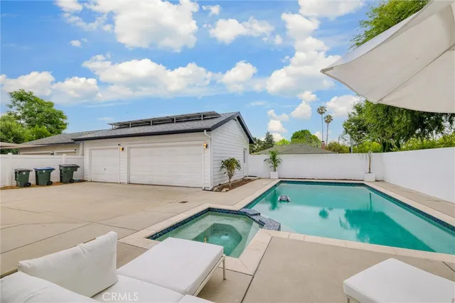 an aerial view of a house with a yard swimming pool and outdoor seating