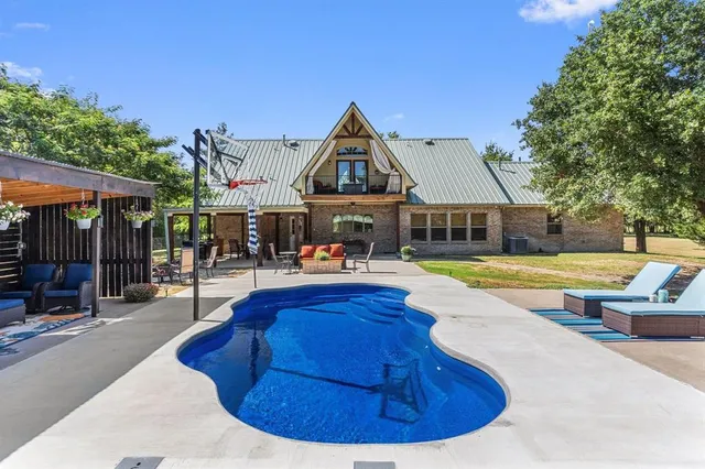 a view of a house with swimming pool and sitting area