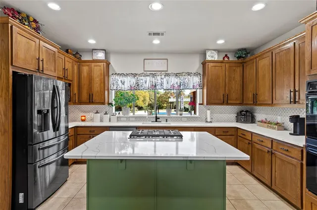 a kitchen with stainless steel appliances granite countertop a sink a stove and refrigerator