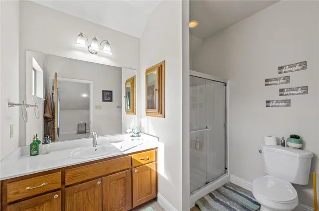 a bathroom with a sink a toilet and shower a mirror