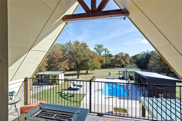 a view of a balcony with wooden floor and fence