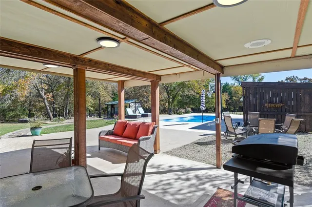 a living room with patio furniture and a floor to ceiling window