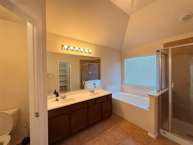 a bathroom with a double vanity sink mirror and bathtub