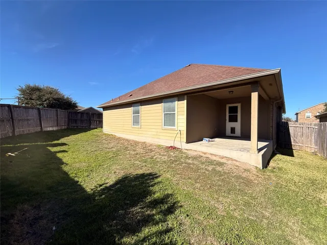 a view of a backyard with wooden fence