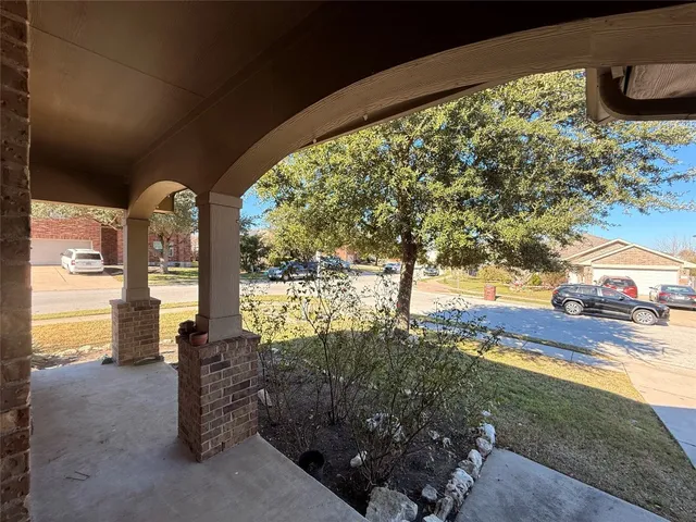 a view of a porch with furniture and a yard