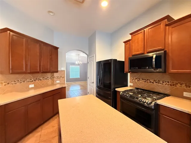 a kitchen with stainless steel appliances a stove a sink and a microwave