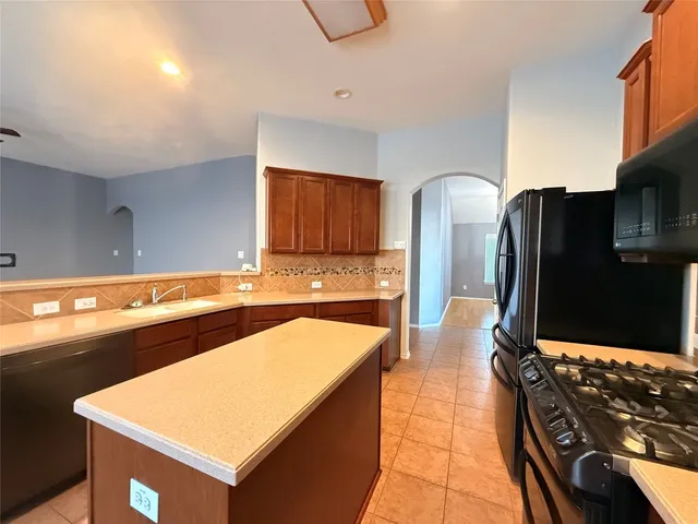 a kitchen with stainless steel appliances granite countertop a sink counter space and a stove