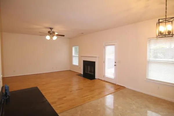an empty room with windows and fireplace