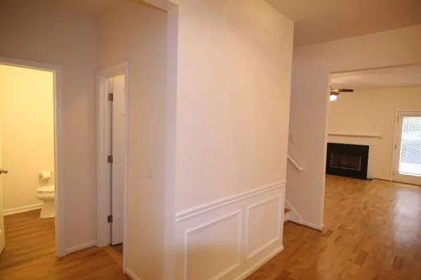 an empty room with wooden floor fireplace and windows