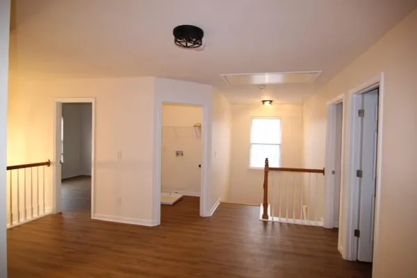 a view of empty room with wooden floor