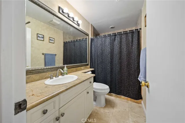 a bathroom with a granite countertop sink toilet and shower