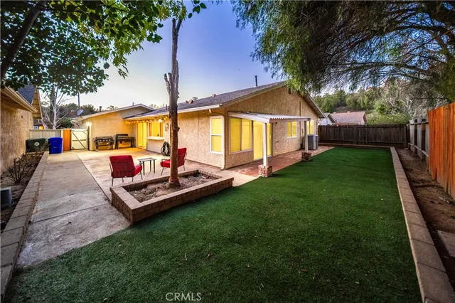 a view of a house with backyard and a tree