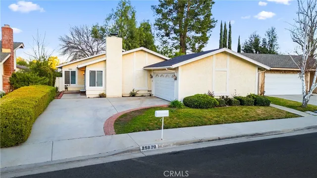 a view of a house with a yard and large tree