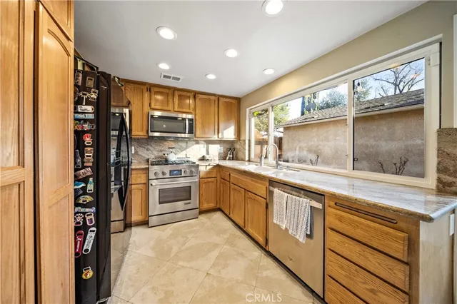 a kitchen with stainless steel appliances granite countertop a stove and a refrigerator